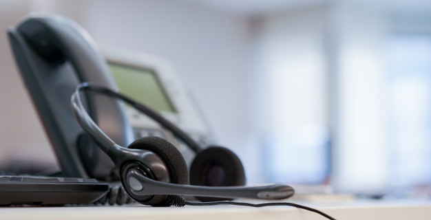 close-up-headset-call-center-with-telephone-office-monitoring-operation-room-concept_42708-408