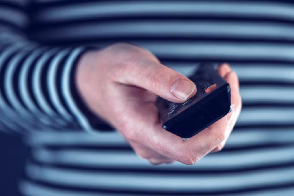 Female hand with television remote control