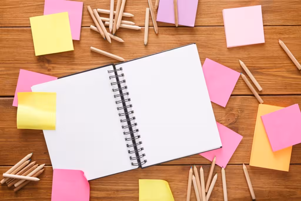 Top view of blank notepad on wooden office desk