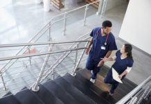 นโยบาย OSCC ศูนย์ช่วยเหลือสังคม Two healthcare colleagues talking on the stairs at hospital
