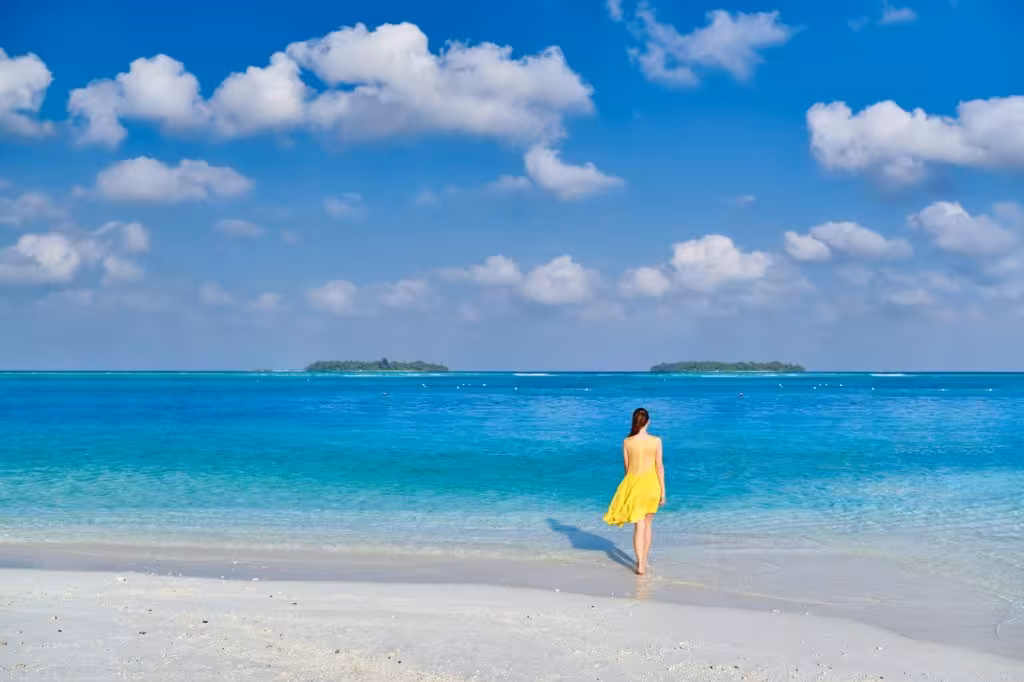 Woman in dress walking on tropical beach