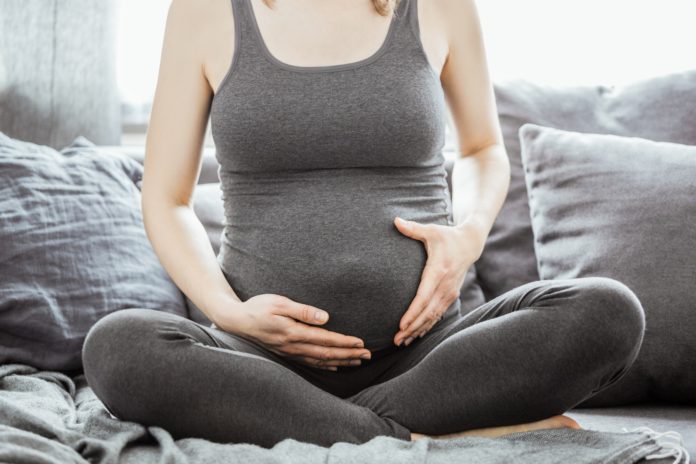 Young pregnant woman touching her belly